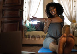 woman exercising at home in front of laptop