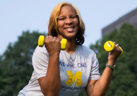 woman exercising outside holding hand weights