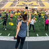 large group of people exercising at Michigan Stadium