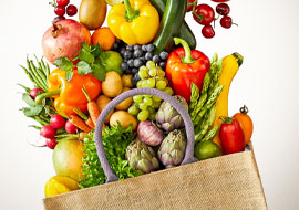 fruit and veggies spilling out of a brown bag