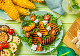 grilled peaches on a salad, corn on the cob