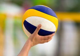 person holding a blue, white and yellow volleyball