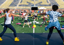 people practicing Zumba in Michigan Stadium