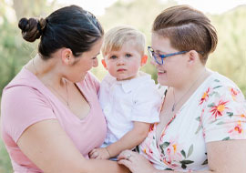 2 people holding a child