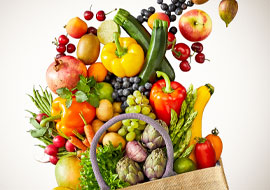 A variety of produce falling out of a canvas bag