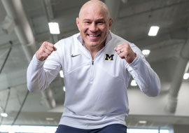 Wrestling coach smiling with fists in the air in celebration