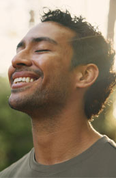 photo of man outside smiling with his eyes closed