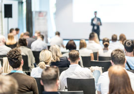 people in an auditorium attending to a coference