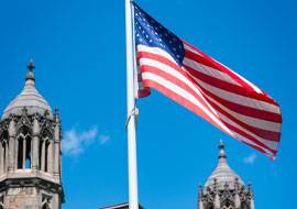 United States flags flying in front of the law quad